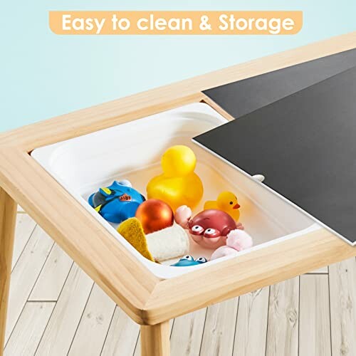 Children's play table with storage compartment containing toys.