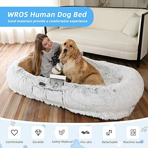 Woman and dog relaxing on large fluffy dog bed in living room.